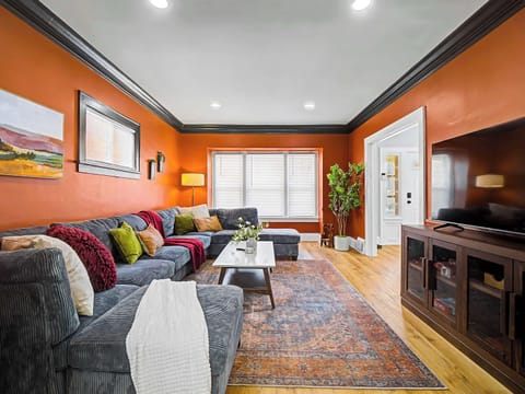 Inviting living room w/ plush seating, warm tones & a large TV for cozy movie nights