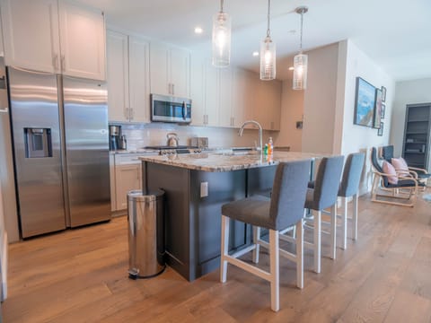 The kitchen boasts high-end finishes, stainless steel appliances, and a spacious island.