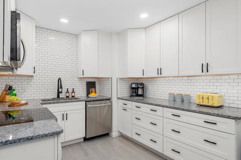 You'll never run out of room in this expansive kitchen. Featuring two long stretches of granite countertops and floor-to-ceiling cabinetry, it’s perfectly equipped for meal prep and organization.