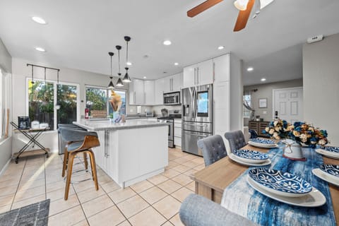 Modern kitchen with white cabinets, island, and stainless appliances.