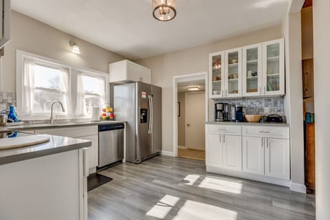 Sunlit modern kitchen with stainless appliances and a coffee bar.