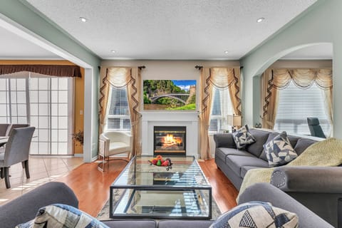 Spacious & bright family room with plenty of seating options, TV,  fire place 