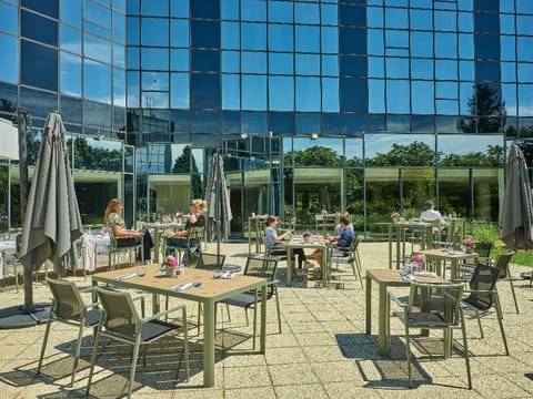 Soak up the sun and enjoy a leisurely moment on this outdoor terrace, perfect for unwinding with views of lush greenery and modern architecture.