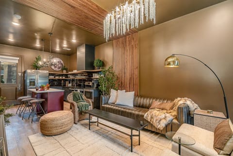 Bright, open living area with a smart flat-screen TV and stylish designer furnishings seamlessly connecting the dining area and kitchen. (1st Floor)