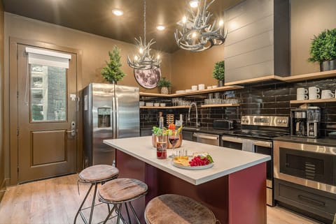 Open floor plan modern kitchen featuring stainless steel appliances and island bar seating. (1st Floor)