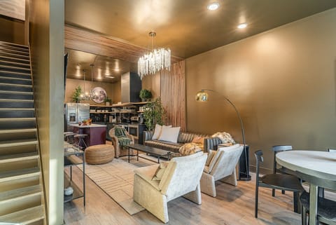 Bright, open living area with a smart flat-screen TV and stylish designer furnishings seamlessly connecting the dining area and kitchen. (1st Floor)