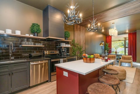 Open floor plan modern kitchen featuring stainless steel appliances and island bar seating. (1st Floor)
