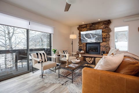 Cozy up by your stone fireplace with leather seating and snowy mountain views from floor-to-ceiling windows.