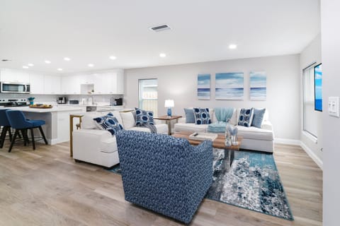 An open living area with cozy seating, stylish decor, and a large smart TV.