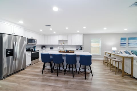 The kitchen is bright and open with 3 bar stools at the console table. 
