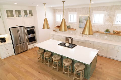 Gourmet kitchen with gas cooktop, double ovens, fridge, and dishwasher. 