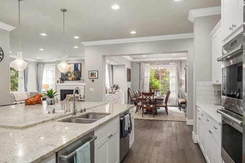 Step into a bright, open-concept kitchen and living area. Perfect for socializing and relaxation, featuring modern lighting, cozy seating, and a beautiful view of the dining space.