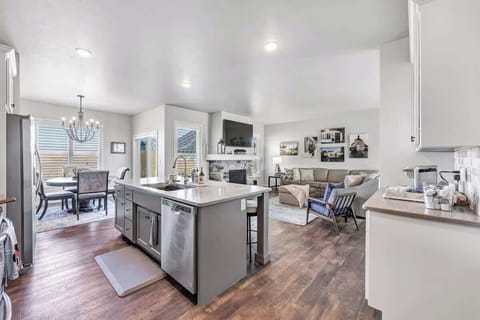 Fully equipped kitchen with pots/pans, utensils, place setting for 5 to 6 people, and modern appliances