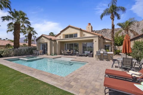 Sunlit backyard w/ sparkling pool, lounge chairs & shaded patio for easy outdoor living