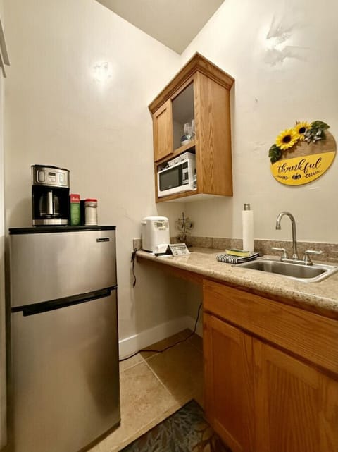 Kitchenette with the essentials: refrigerator, microwave, sink, and drip coffee maker