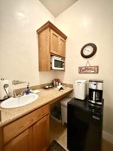Kitchenette stocked with the essentials: sink, microwave, refrigerator and coffee maker