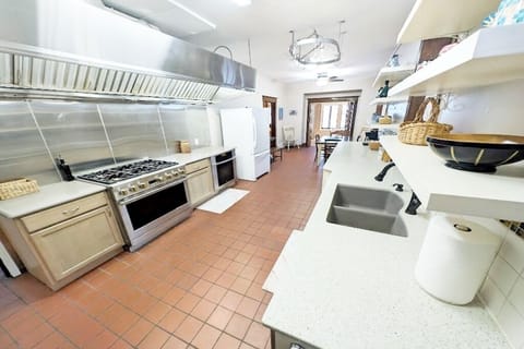 A well-lit, fully-equipped kitchen with a stove, fridge, and cooking needs!