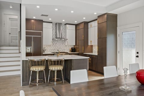 Dining area with kitchen and steps to primary suite beyond