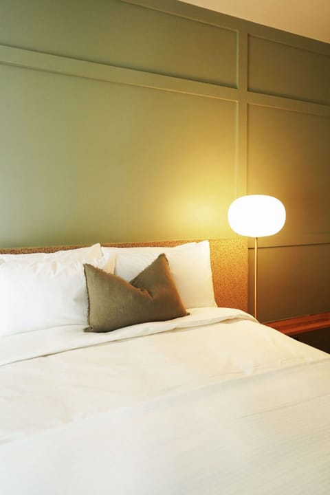 Relax beside soft glow lighting and beautifully layered bedding.