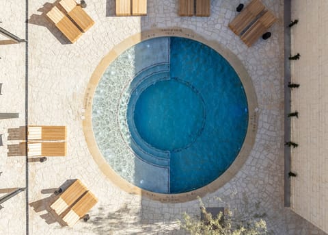 Dive into a sunlit pool oasis with serene seating.