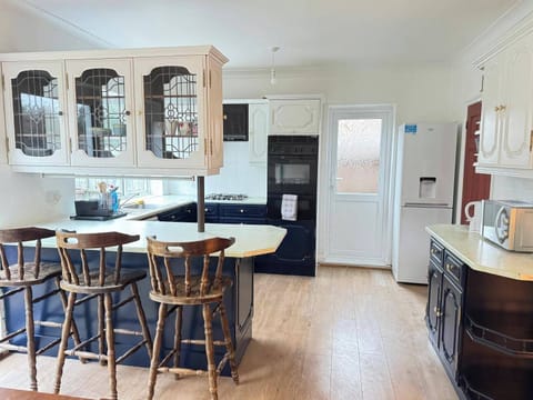 Large kitchen with breakfast counter and stools.