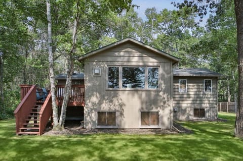 Picture of home from the large backyard. Large deck with table and chairs.