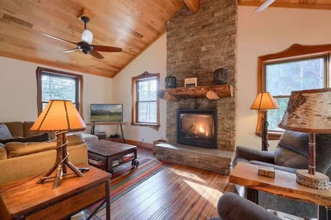 Main floor living room with cozy seating, gas fireplace, games, and books