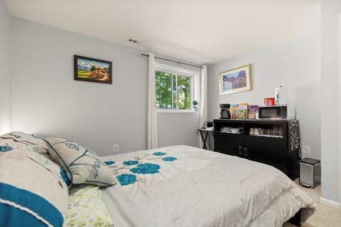 Primary bedroom featuring a queen size bed, plush linens, and snack bar. 