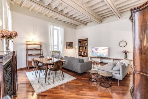 The living room with large dining table, smart TV and 2 comfy couches. 