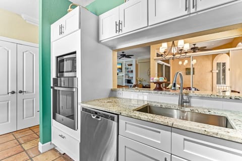 Kitchen area with stainless steel sink. The pass-through is to the dining room.
