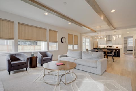 Living Area: Enjoy the open and welcoming vibe of this living room with its modern decor and abundant seating, flowing seamlessly into a fully equipped kitchen, perfect for entertaining or a cozy night in.