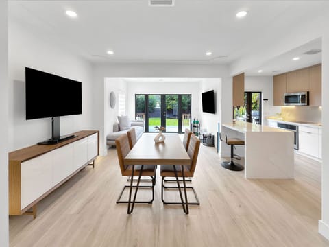 Open concept layout includes living, dining, kitchen, and access to patio.  