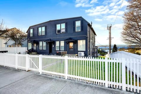 Charming and spacious duplex with a welcoming white picket fence, just steps away from serene ocean views.