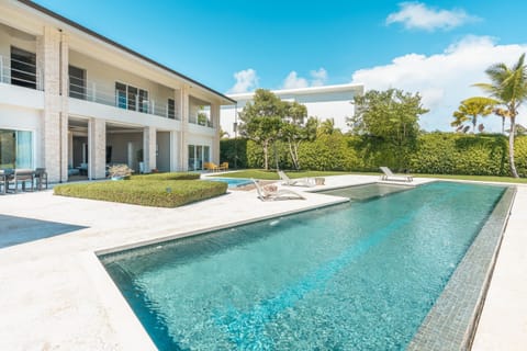 - Expansive private pool area with resort-style outdoor living, sun loungers, and serene garden views  
- Open layout enhances relaxation for families and groups seeking a peaceful getaway  
- Bright blue water, palm trees, and spacious decking create a refreshing stay