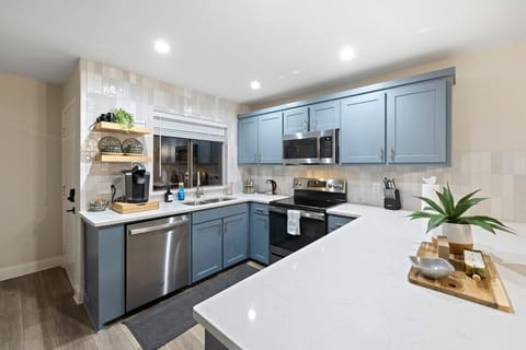 Charming Kitchen: Cook up a feast in the sleek, modern kitchen with stylish blue cabinetry!