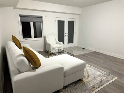Modern living room with chic furniture, gold accents, and bright French doors.