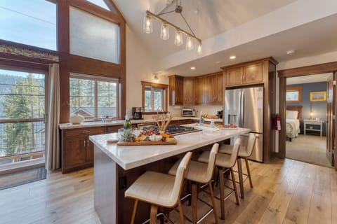 Kitchen features an island with barstool seating.