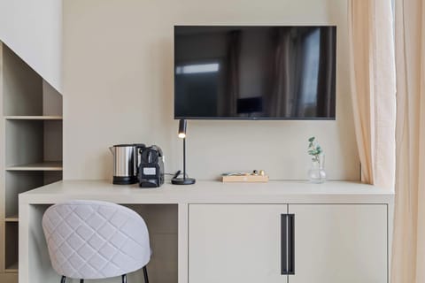 Functional Workspace and Entertainment Area – Wall-mounted TV, small desk, and a cozy chair create a perfect blend of comfort and productivity.