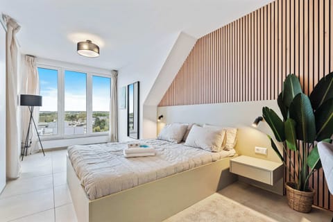 Inviting Living and Sleeping Space – Unwind in a cozy area featuring a queen-sized bed and a sophisticated wooden accent wall.