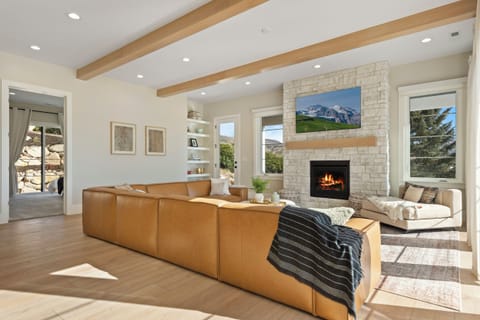Custom furnishings, Smart TV and large fireplace with a huge leather sectional