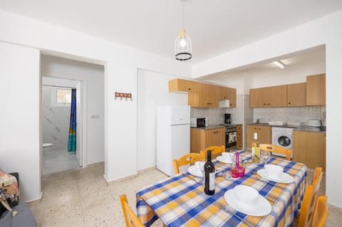 Open-plan living room with sofa, dining area, kitchen, A/C, WiFi internet, and satellite TV