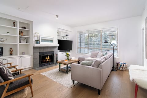 Cozy living area with fireplace, Smart 4K HDTV, and patio with hot tub access.