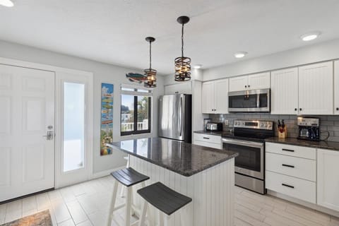 Kitchen includes microwave oven, stove, toaster, coffee maker and blender