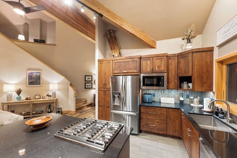 Full kitchen featuring all stainless steel appliances, air fryer, and five-burner stovetop.