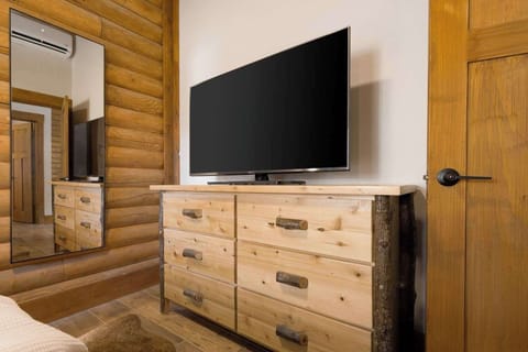 The handcrafted log dresser and full-length mirror in the Double Queen Suite offer both style and practicality for your mountain getaway.