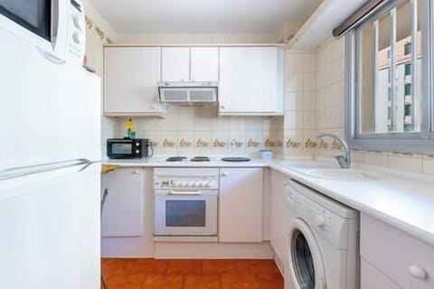 Kitchen equipped with refrigerator, microwave, oven and washing machine. Tableware and utensils for (1)