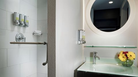 Refresh in a sleek bath with bright vanity and mirror.