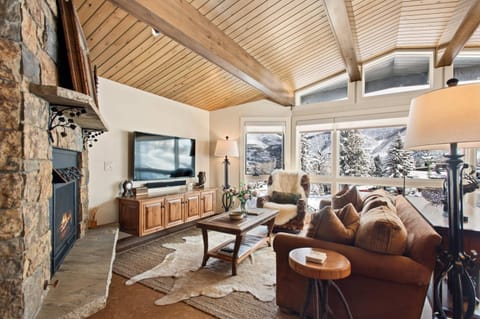 The living room has a cozy chalet feel that invites you to relax after a day of skiing