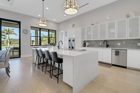 The waterfall island w/barstool seating defines the kitchen space; cookware, dinnerware, many kitchen tools & small electrical appliances are included
