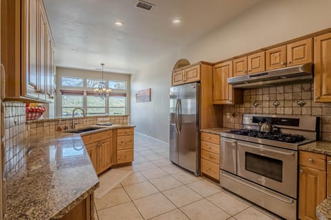 The rich wood cabinets complement the sleek stainless steel appliances, creating a modern yet warm atmosphere.
